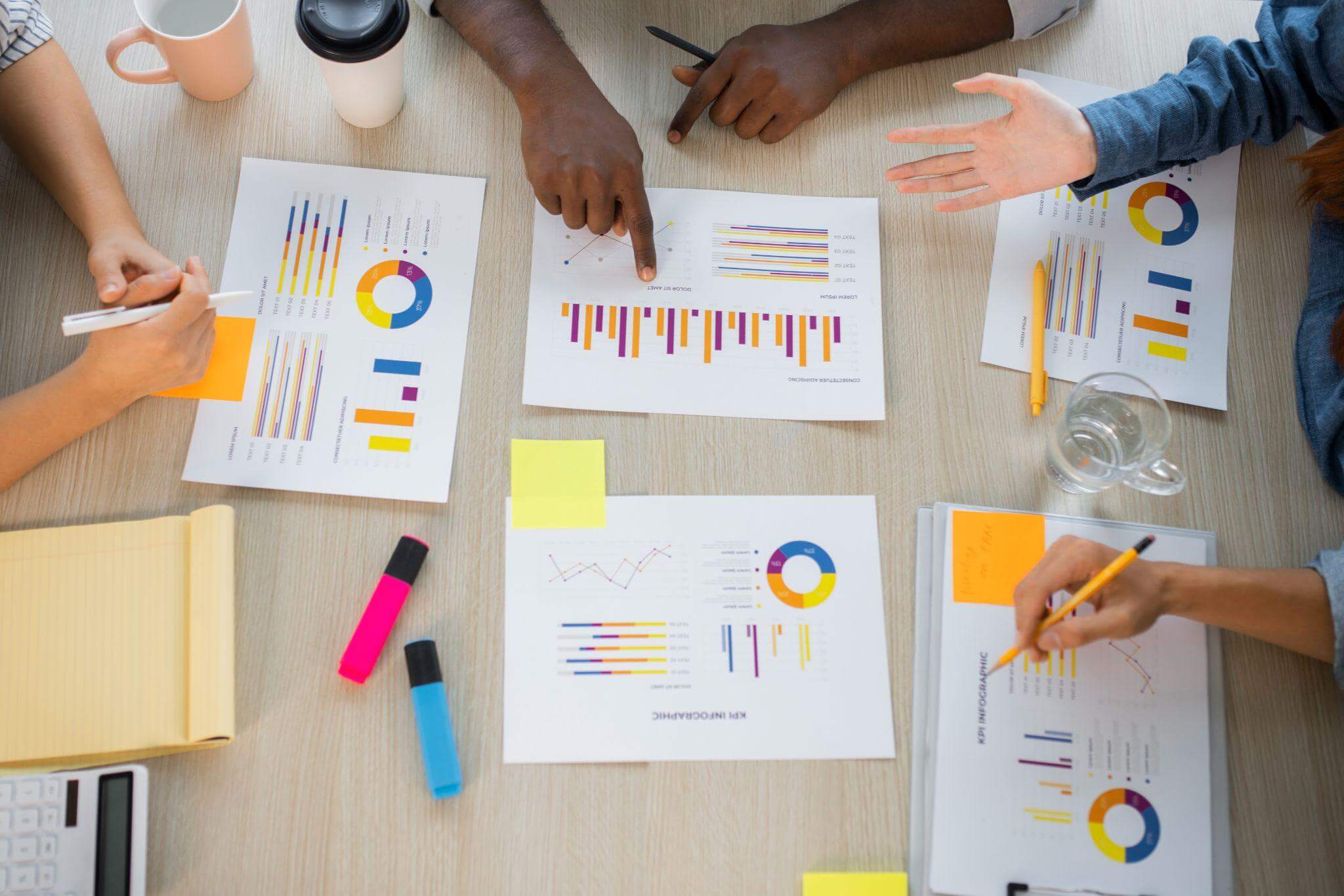 Team reviewing printed SEO analytics charts and performance graphs at a table