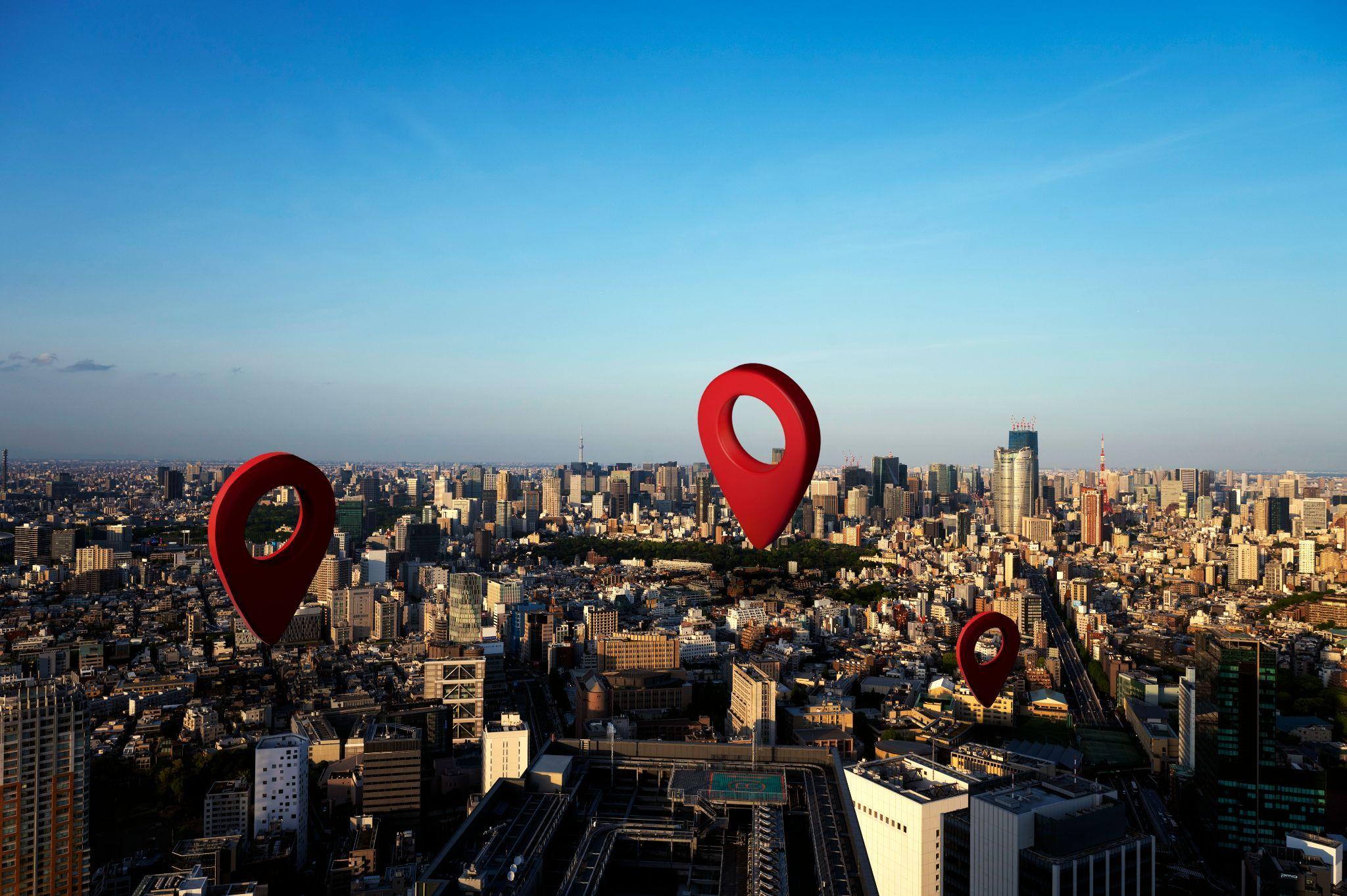 City skyline with red location pins illustrating local SEO reach and multi-location visibility