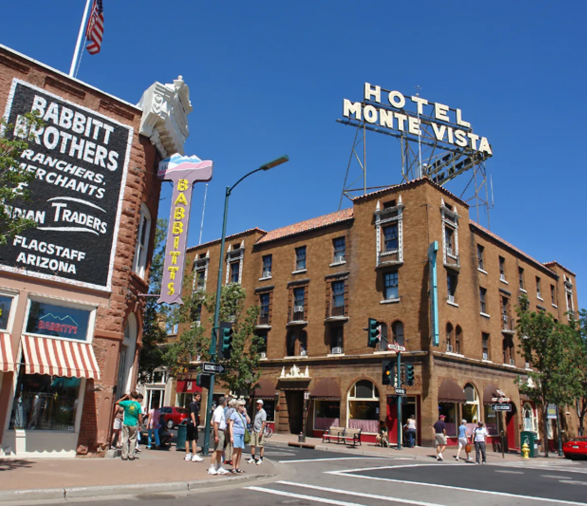 Historic brick storefronts and the Hotel Monte Vista sign on a sunny downtown Flagstaff corner