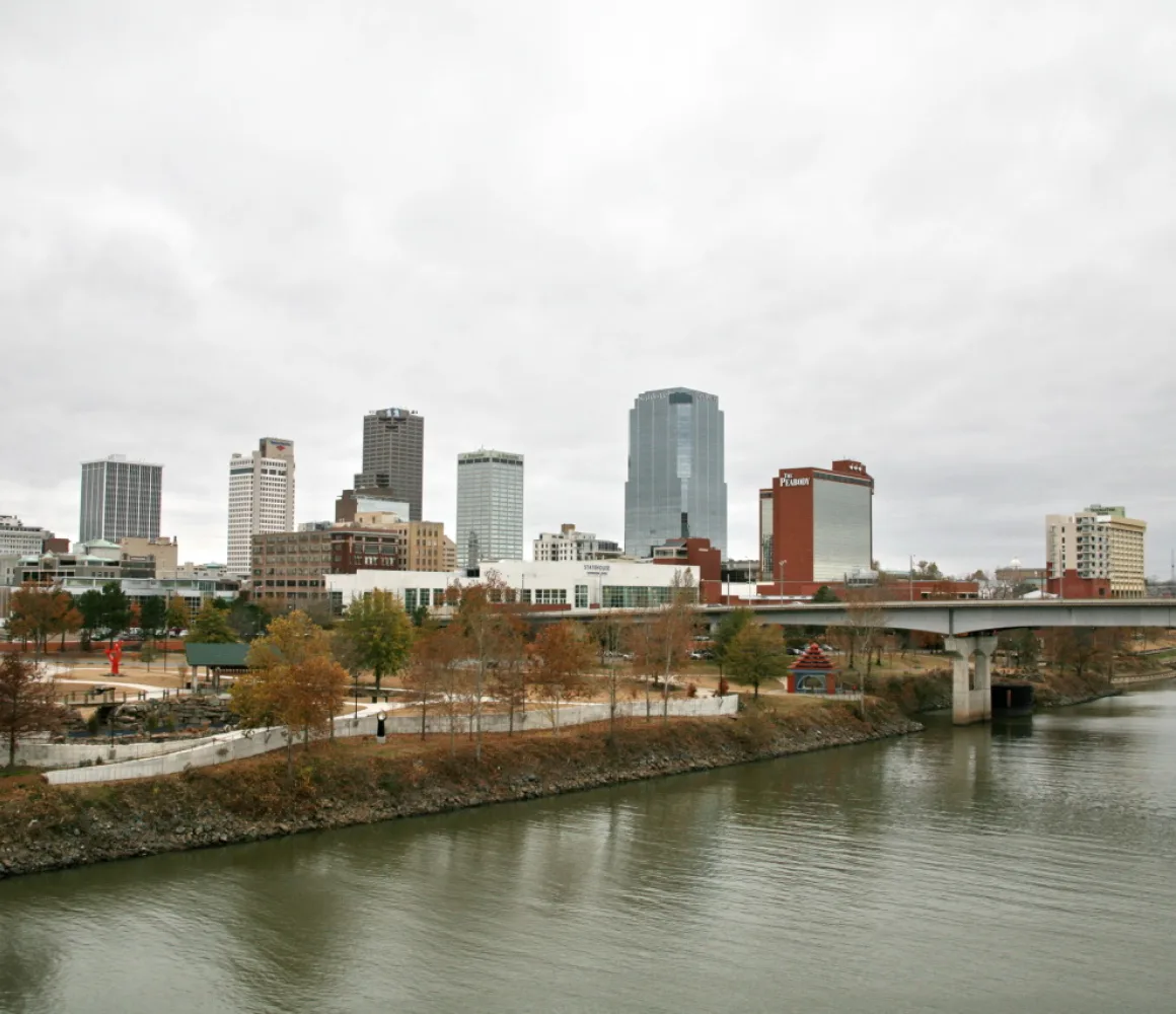 Little Rock skyline and riverfront park across the Arkansas River under heavy grey cloud